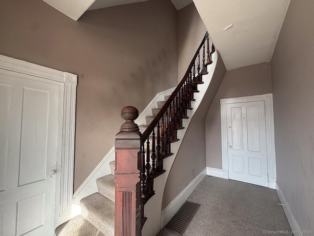 staircase featuring carpet floors, baseboards, and visible vents