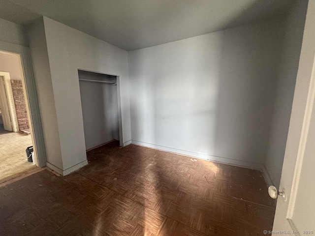 unfurnished bedroom featuring a closet and baseboards