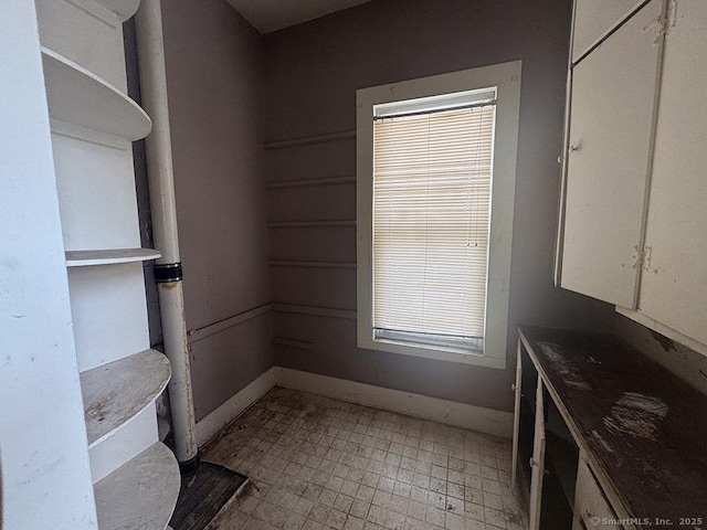 interior space featuring baseboards and light floors