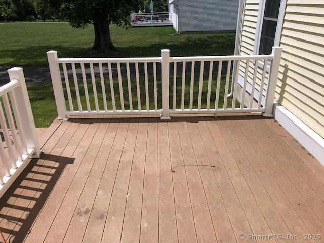 wooden terrace featuring a lawn