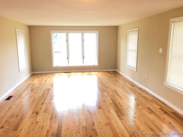 spare room with a wealth of natural light and baseboards