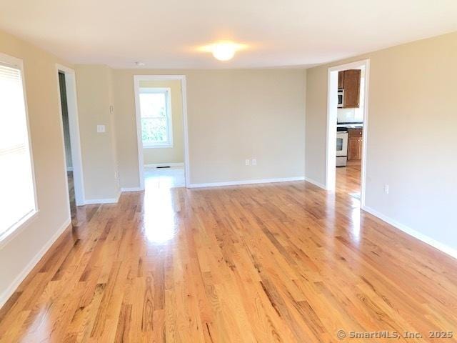 empty room featuring baseboards and light wood-style floors