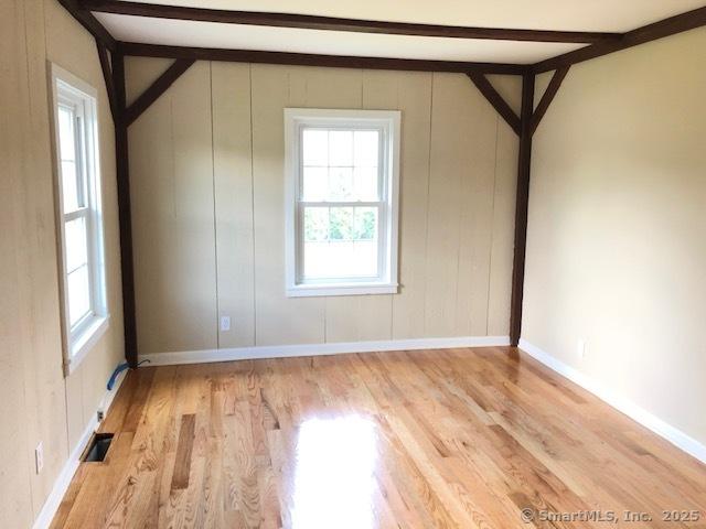 bonus room with wood finished floors, visible vents, and baseboards