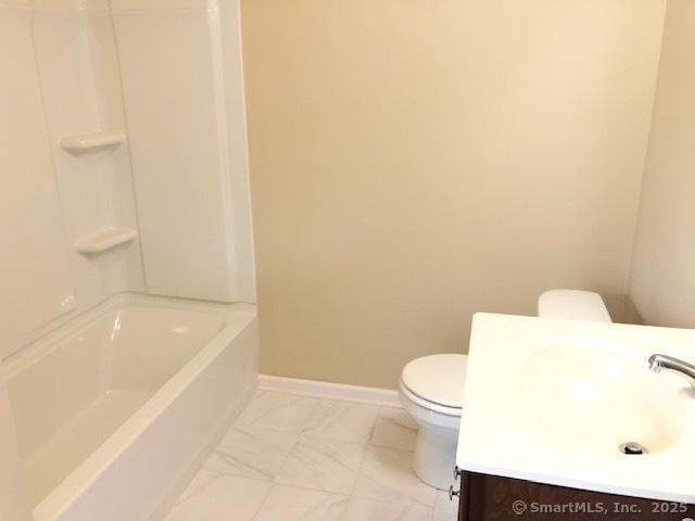 full bathroom with vanity, toilet, baseboards, and marble finish floor