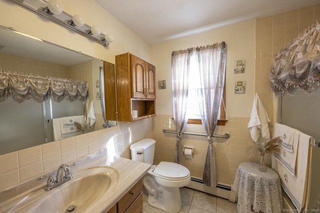 bathroom featuring tile walls, toilet, baseboard heating, vanity, and tile patterned floors