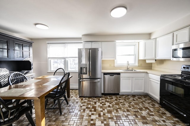 kitchen with stainless steel appliances, light countertops, and white cabinets