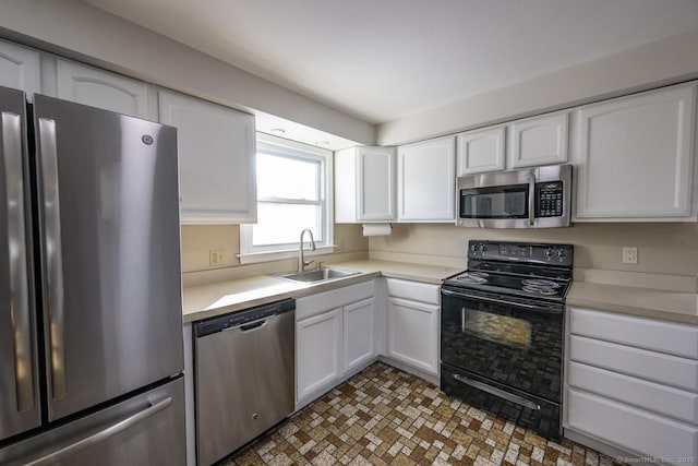 kitchen with white cabinetry, appliances with stainless steel finishes, light countertops, and a sink