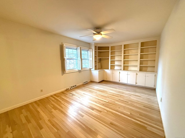 unfurnished room featuring light wood finished floors, visible vents, baseboards, and a ceiling fan