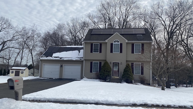 colonial inspired home featuring driveway and an attached garage