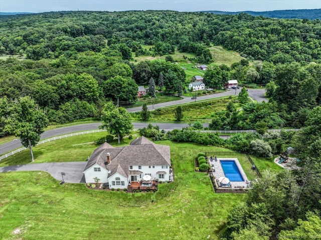 drone / aerial view featuring a wooded view