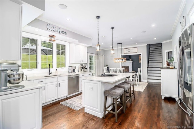 55 Country Woods Ln, Southbury, CT 06488 - kitchen with stainless steel appliances, a sink, a kitchen island, white cabinetry, and light countertops