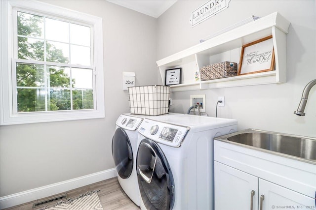 55 Country Woods Ln, Southbury, CT 06488 - washroom featuring cabinet space, light wood-style flooring, a sink, separate washer and dryer, and baseboards