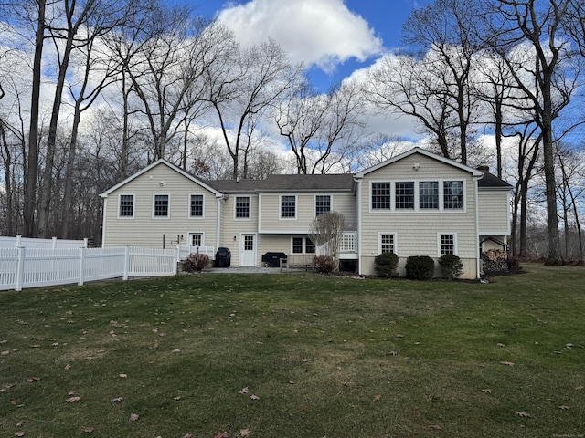 back of house featuring a yard, a patio, and fence