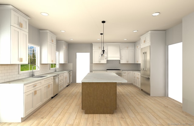 kitchen with high end appliances, light wood-style floors, a sink, and a kitchen island