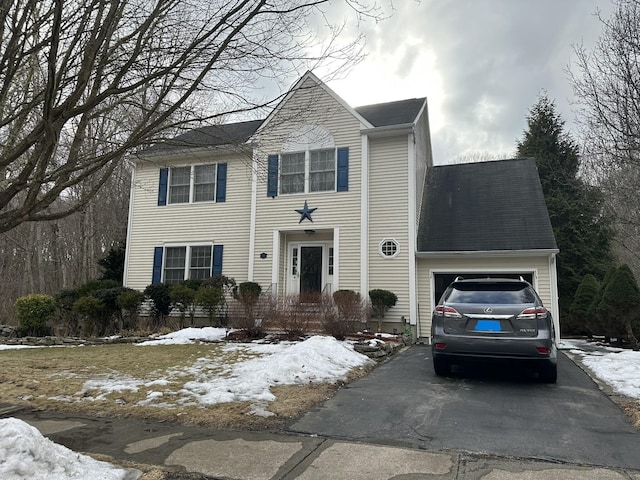 colonial house with aphalt driveway and an attached garage