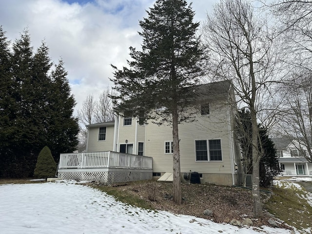 view of snowy exterior featuring a deck and central air condition unit