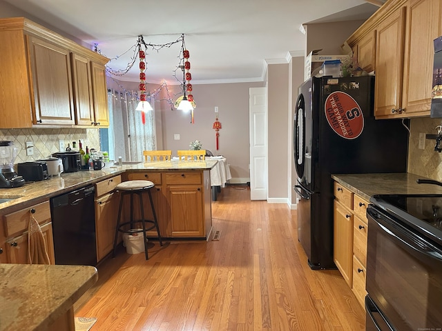 75 Heather Glen Ln, Groton, CT 06355 - kitchen featuring black appliances, a peninsula, tasteful backsplash, light wood-style flooring, and ornamental molding