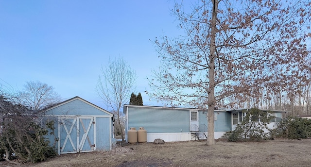 back of house with a storage unit and an outdoor structure