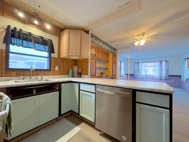 kitchen with a sink, light wood-style floors, light countertops, and dishwasher