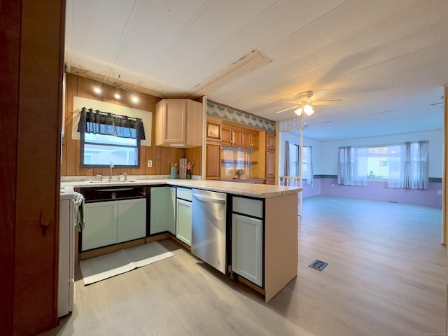 kitchen featuring open floor plan, light countertops, a sink, and light wood finished floors