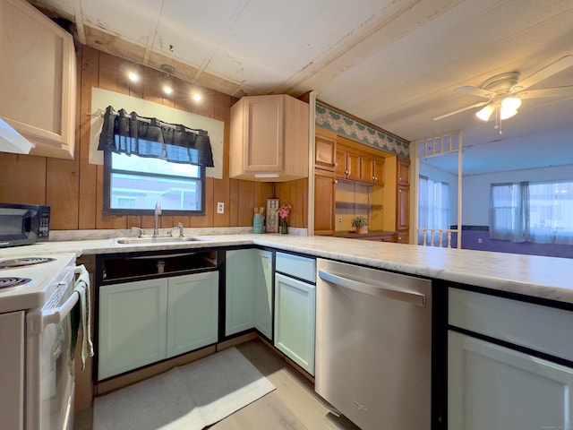 kitchen featuring black microwave, light countertops, a sink, and stainless steel dishwasher