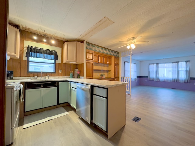 kitchen with electric stove, light countertops, open floor plan, dishwasher, and a peninsula