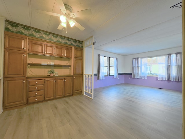 kitchen with open floor plan, light wood-style flooring, brown cabinets, and ceiling fan