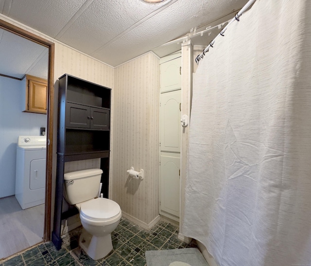 full bathroom featuring a textured ceiling, toilet, and washer / dryer