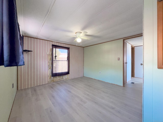 spare room featuring a ceiling fan, visible vents, and light wood-style flooring