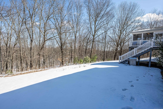 snowy yard featuring stairway