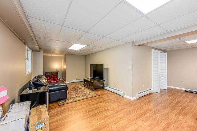 living room with light wood-style flooring, baseboard heating, a baseboard radiator, and a paneled ceiling