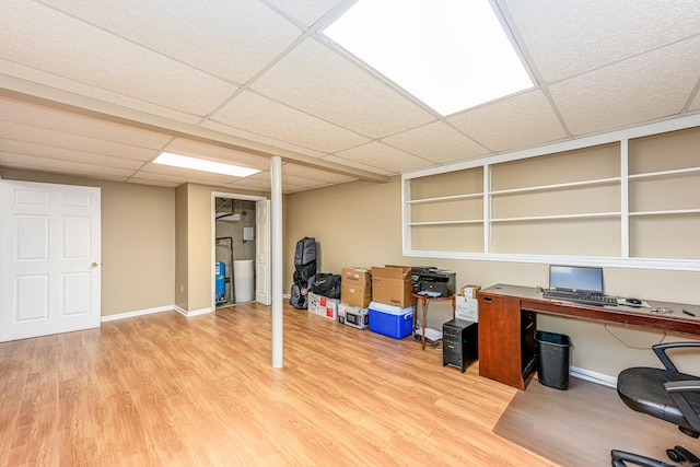 office featuring a paneled ceiling, baseboards, and wood finished floors