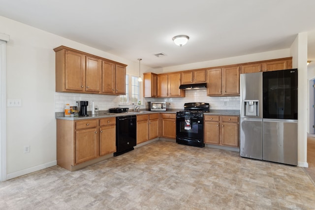 kitchen with black appliances, brown cabinetry, under cabinet range hood, and a sink