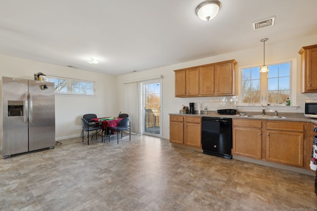 kitchen featuring visible vents, stainless steel appliances, decorative backsplash, and a sink