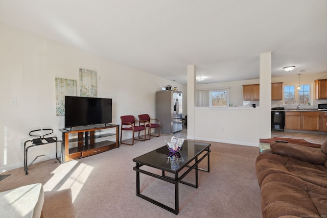 living area featuring light colored carpet and baseboards