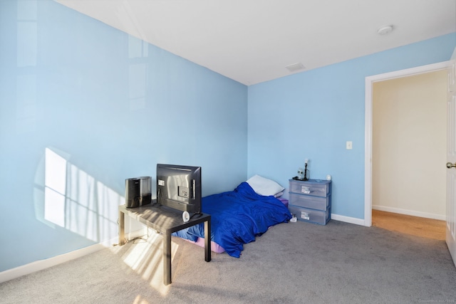 bedroom featuring visible vents, baseboards, and carpet