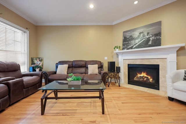 living area featuring crown molding, recessed lighting, a fireplace, and wood finished floors