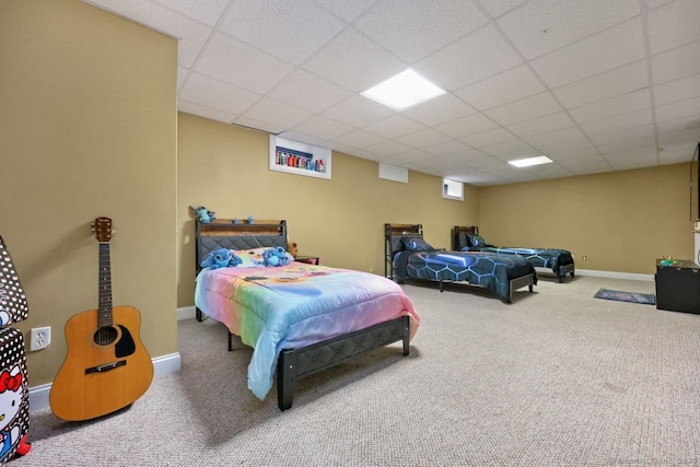 bedroom featuring carpet floors, a paneled ceiling, and baseboards