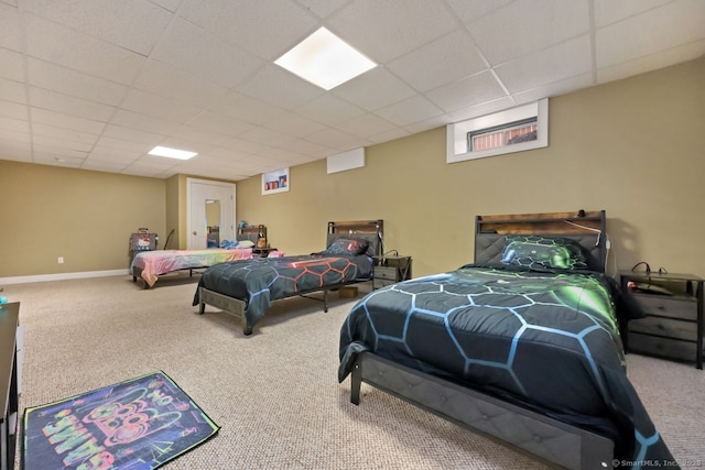 bedroom featuring carpet floors, a drop ceiling, and baseboards