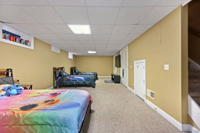 bedroom featuring a paneled ceiling, carpet flooring, visible vents, and baseboards