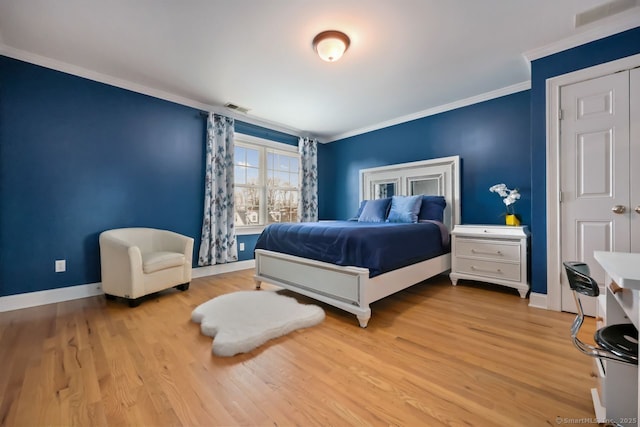 bedroom featuring baseboards, visible vents, wood finished floors, and ornamental molding