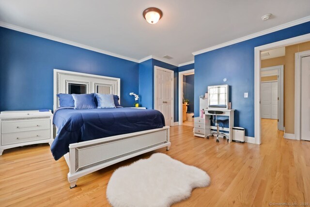 bedroom with baseboards, ornamental molding, visible vents, and light wood-style floors