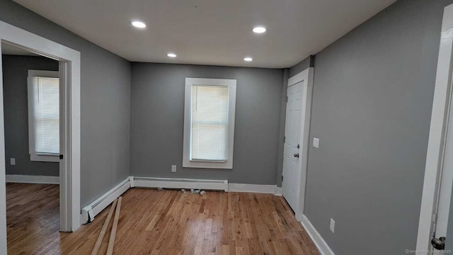 interior space with light wood-type flooring, a baseboard radiator, baseboards, and recessed lighting