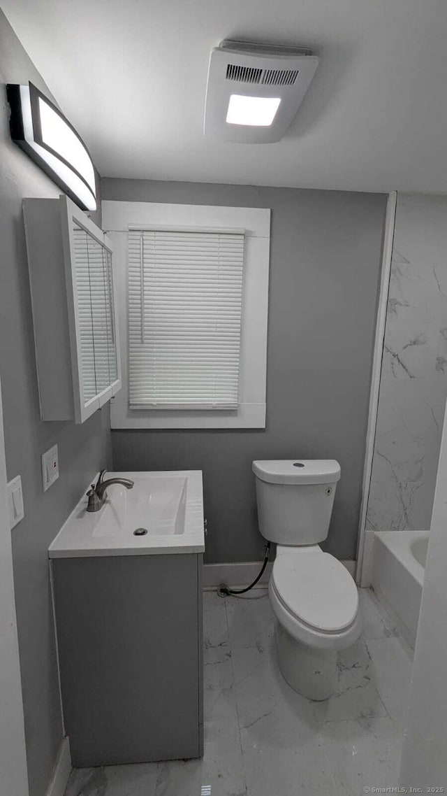 full bath with toilet, marble finish floor,  shower combination, and vanity