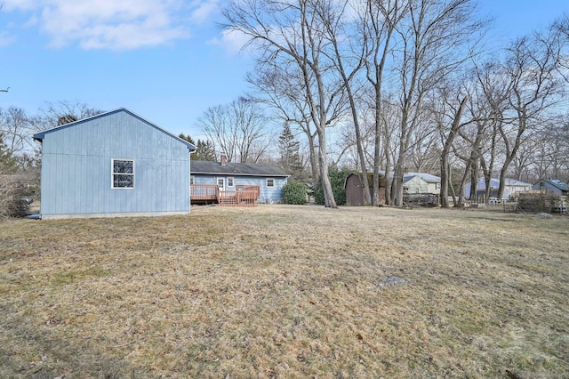 view of yard with an outdoor structure, a deck, and a storage unit