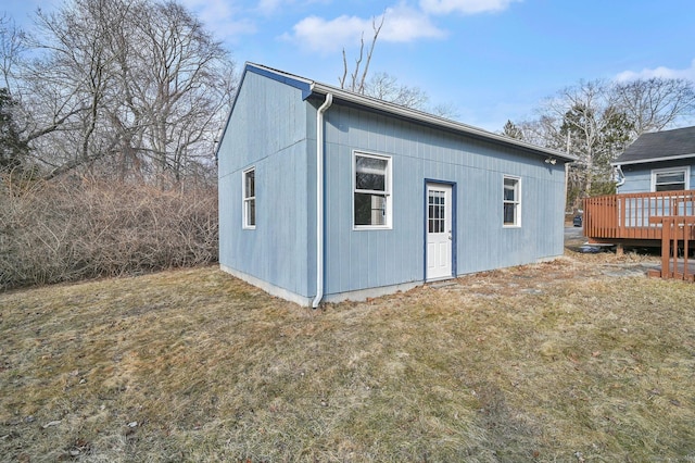 back of house featuring a lawn and a wooden deck