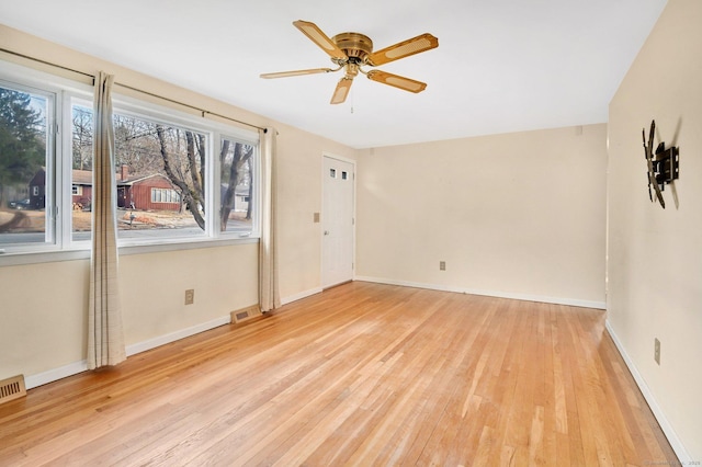 unfurnished room with light wood-style floors, baseboards, visible vents, and ceiling fan