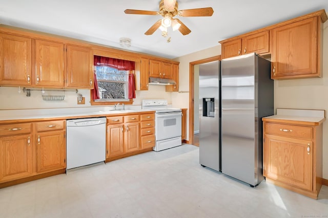 kitchen featuring under cabinet range hood, white appliances, a sink, light countertops, and light floors