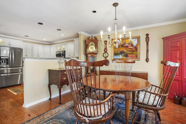 dining space featuring a chandelier, ornamental molding, wood finished floors, and recessed lighting