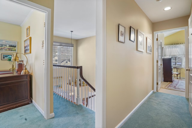 hallway featuring carpet, an upstairs landing, and baseboards